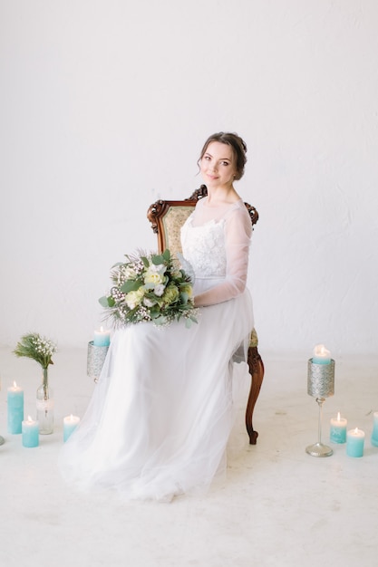 Bella sposa davanti alle decorazioni di nozze con fiori e candele