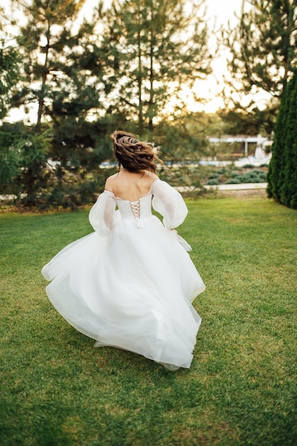 Bella sposa di nozze che corre in giardino