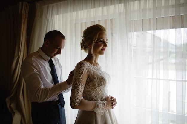 Bella sposa e lo sposo in una camera d'albergo