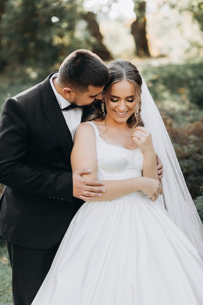 Bella sposa e sposo al tramonto nel verde della natura.