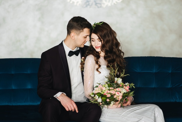 Bella sposa in abito bianco con bouquet di sposa e lo sposo bello