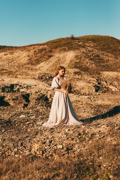 bella sposa in piedi sul bellissimo paesaggio durante il tramonto