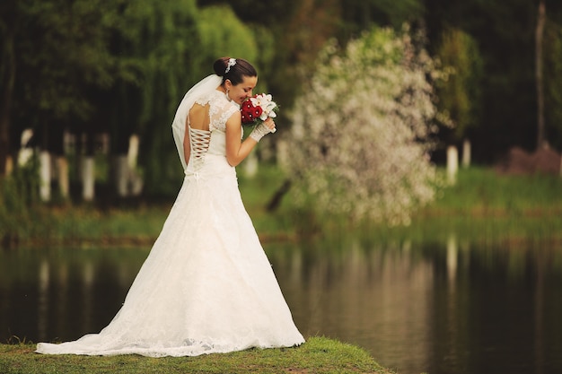 Bella sposa in posa vicino al lago