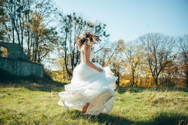 bella sposa in un abito da sposa nel parco in autunno