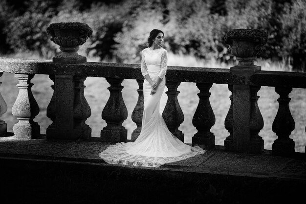 Bella sposa in un abito di pizzo in piedi su un balcone