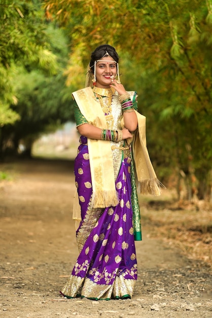 Bella sposa indiana in saree tradizionale che posa all'aperto nel parco