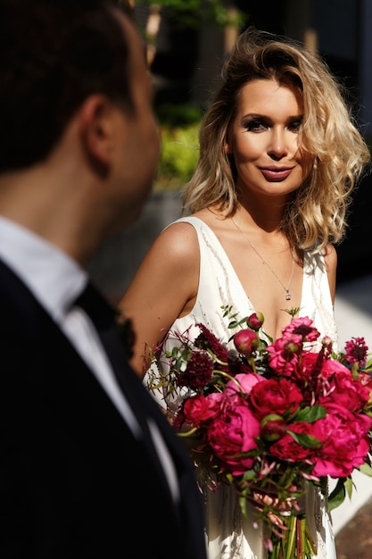 Bella sposa sta davanti al suo uomo per la strada