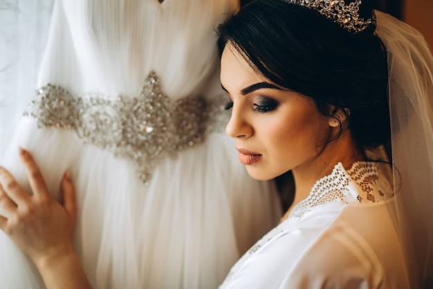 Bella sposa vestirsi prima della cerimonia di nozze