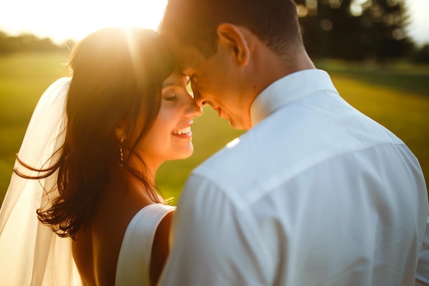 Bella sposi al tramonto Sposa sposo in abito da sposa con bouquet di fiori Romantico