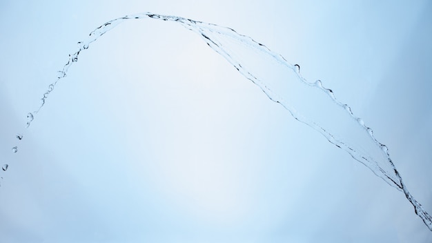 Bella spruzza un'acqua pulita su sfondo blu sfumato.