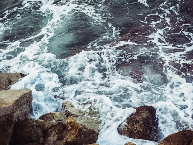 Bella spuma marina, onde tempestose e rocce