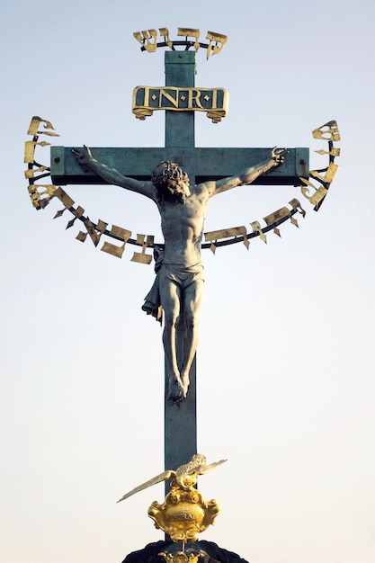 Bella statua di bronzo della crocifissione di Gesù Cristo durante l'alba Statuario della Santa Croce con Calvario Ponte Carlo Praga Repubblica Ceca giornata di sole cielo sereno