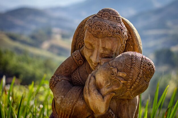 Bella statua di un uomo e una donna con copricapi orientali che si baciano con paesaggio sfocato sullo sfondo