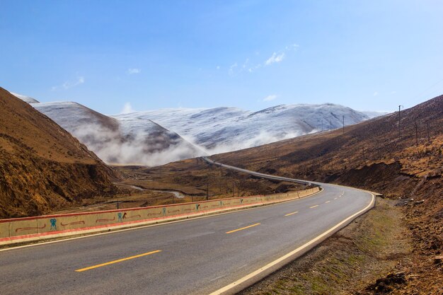 Bella strada di inverno nel Tibet sotto la montagna della neve, Sichuan, Cina