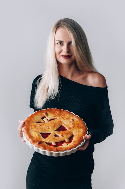 Bella strega con una torta per halloween