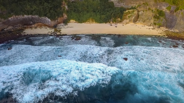 Bella struttura delle onde dell'oceano scuro con schiuma bianca Drone che riprende il surf che rompe nell'Oceano Indiano sull'isola di Nusa Penida Filmati di vista a volo d'uccello Grande onda nella capitale di Bali Surfig