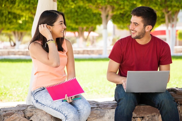 Bella studentessa che parla e flirta con un ragazzo che le piace a scuola