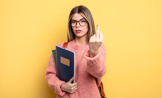 Bella studentessa che si sente arrabbiata, infastidita, libri e zaino ribelli e aggressivi