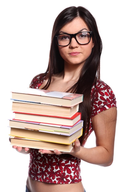 Bella studentessa con gli occhiali in piedi e in possesso di libri