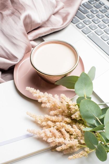 Bella tazza di caffè rosa smaltata con coperta e laptop