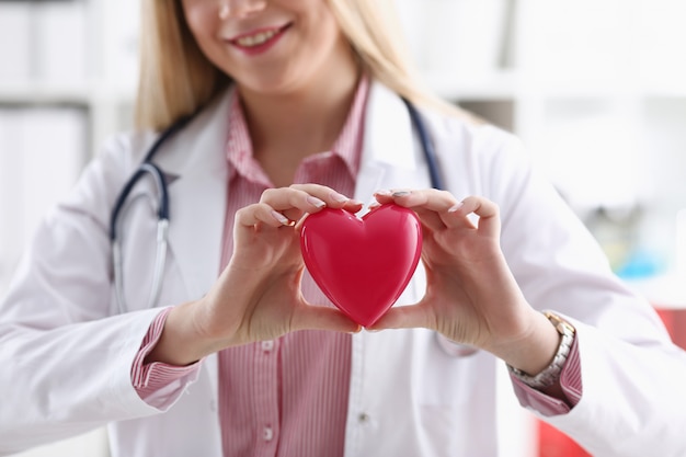 Bella tenuta femminile bionda sorridente del medico