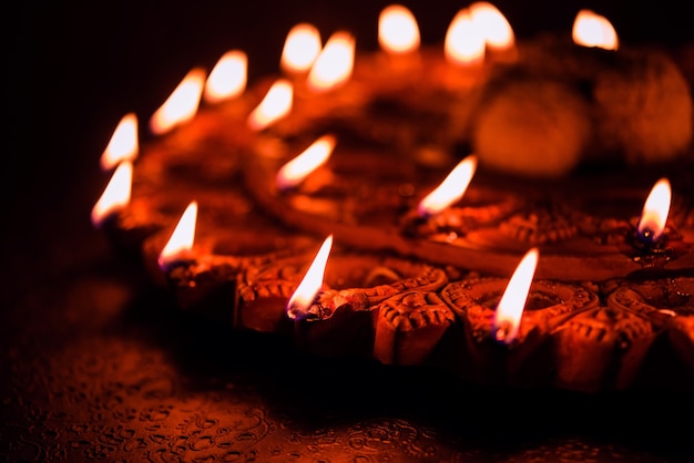 Bella terracotta illuminata Diwali diya Piatto nella notte, illuminazione lunatica, messa a fuoco selettiva