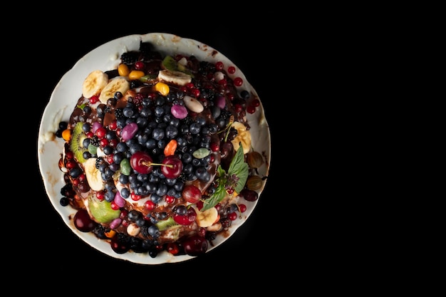 Bella torta decorata con varie bacche e frutti su una vista dall'alto di sfondo scuro