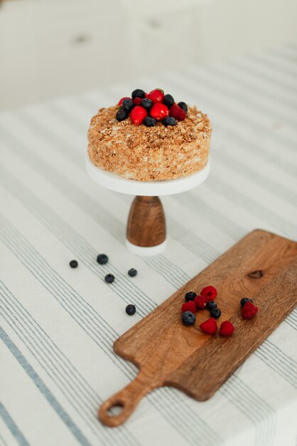 Bella torta di miele e frutti di bosco maturi su un alimento dolce tavolo bianco