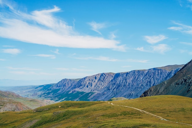 Bella veduta aerea di collina verde e grandi montagne sotto il cielo blu Catena montuosa lunga