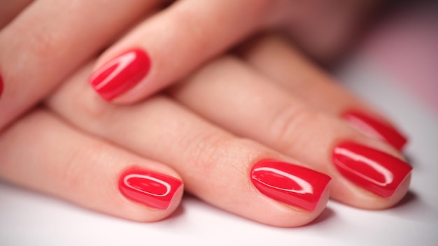 Bella vernice rossa brillante sul concetto di unghie manicure per mani femminili