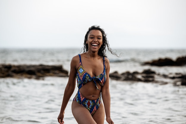 Bella vestibilità giocosa donna nera in bikini in una spiaggia vulcanica a Santo Antao, Capo Verde