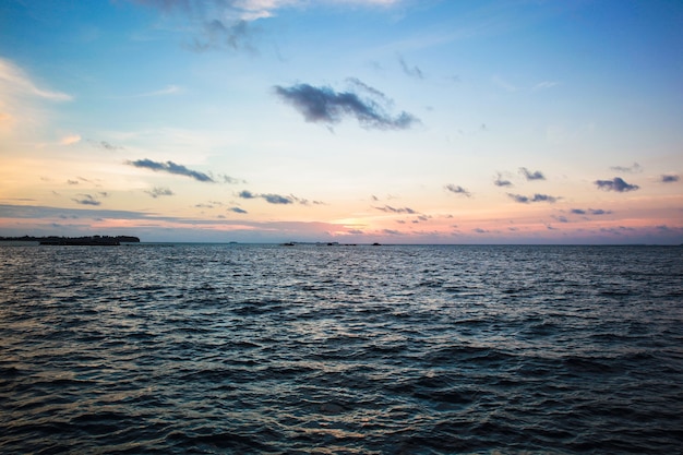 Bella vista del tramonto in mare con nuvole drammatiche sul cielo blu giallo oro rosa una sera d'estate