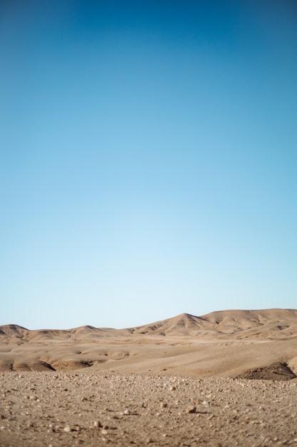 Bella vista delle colline sabbiose nel deserto sotto il cielo blu