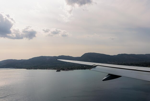 Bella vista di un'ala di un aereo e di un'isola rocciosa in mare