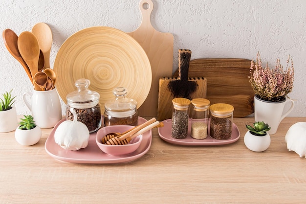 Bella vista frontale di vari utensili da cucina area di stoccaggio per spezie caffè piante da interno nell'arredamento di una cucina moderna