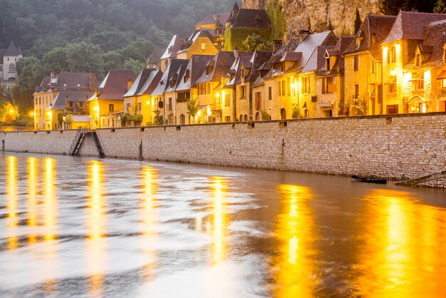 Bella vista sul fiume Dordogne e sul villaggio illuminato di La Roque Gageac durante il tempo piovoso in Francia