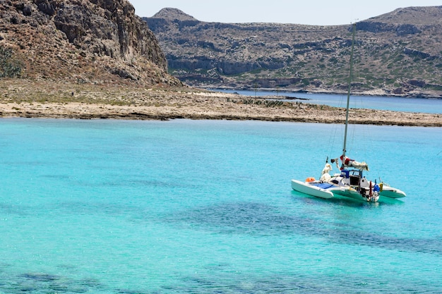 Bella vista sul mare con la barca a vela bianca nel mare blu. Abbassò le vele, calmo.