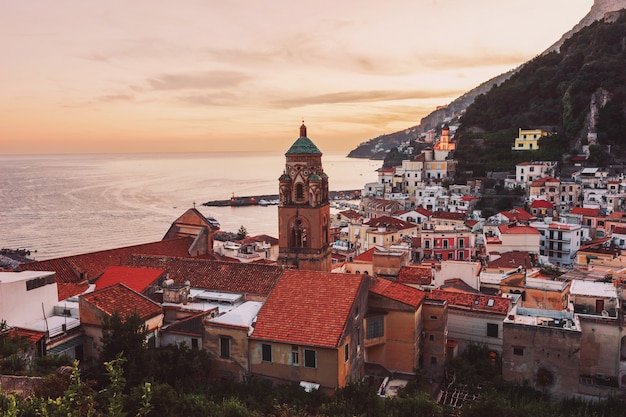 Bella vista sulla cattedrale e sulla città di Amalfi con case colorate al tramonto. Panorama serale di Amalfi con vista sul tramonto e sul mare. Costiera Amalfitana, Italia