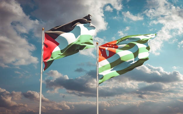 Belle bandiere dello stato nazionale della Palestina e dell'Abkhazia insieme sul cielo blu. Grafica 3D