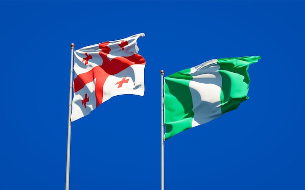 Belle bandiere di stato nazionali della Georgia e della Nigeria insieme sul cielo blu