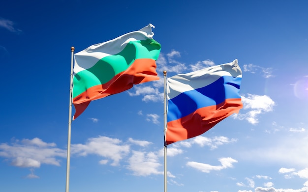 Belle bandiere di stato nazionali della Russia e della Bulgaria insieme sul cielo blu. Grafica 3D