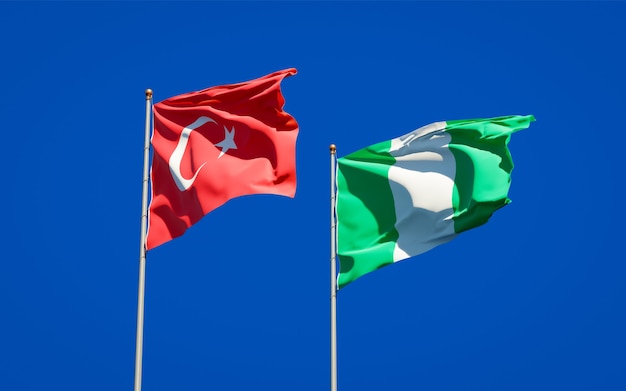 Belle bandiere di stato nazionali della Turchia e della Nigeria insieme sul cielo blu