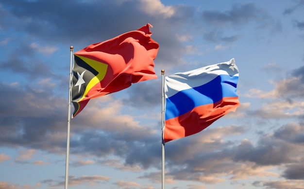 Belle bandiere nazionali dello stato di Timor orientale e Russia insieme sul cielo blu. Grafica 3D