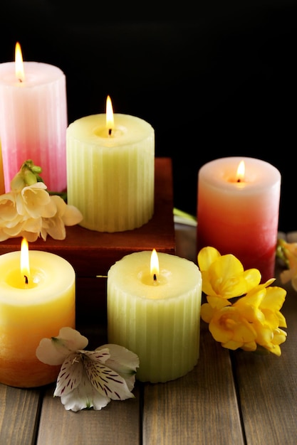 Belle candele con fiori su fondo di legno
