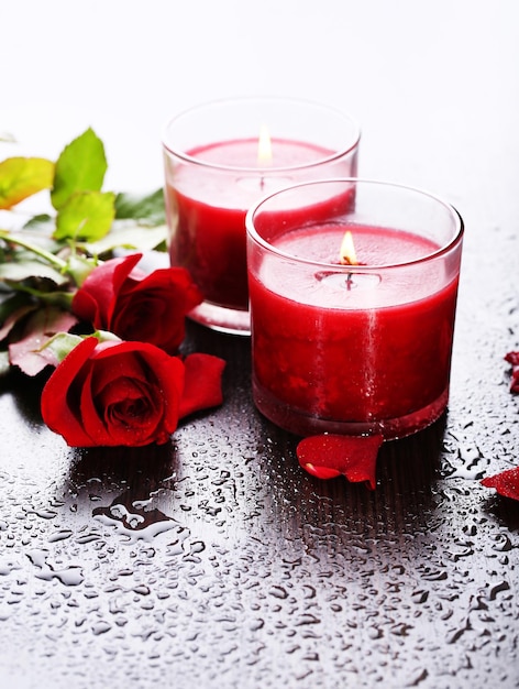Belle candele rosse romantiche con fiori, primi piani