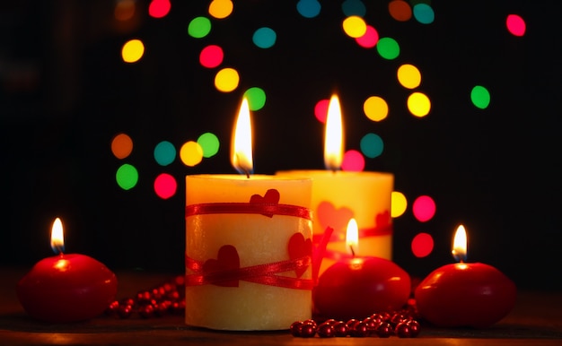 Belle candele sul tavolo di legno su sfondo luminoso