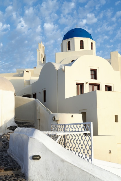 Belle case bianche e chiesa locale con la cupola blu a OIA su Santorini