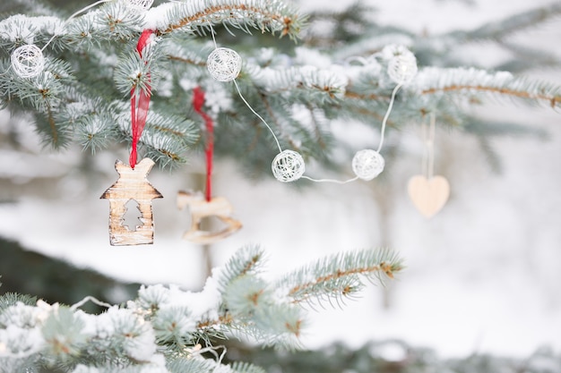 Belle decorazioni su un albero di Natale con la neve all'aperto