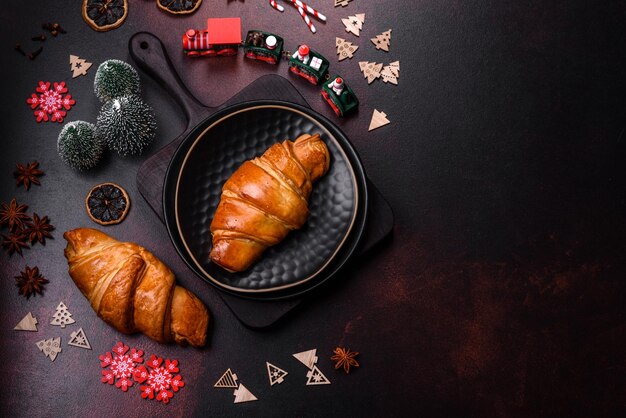 Belle diverse decorazioni natalizie e croissant su un tavolo di cemento marrone