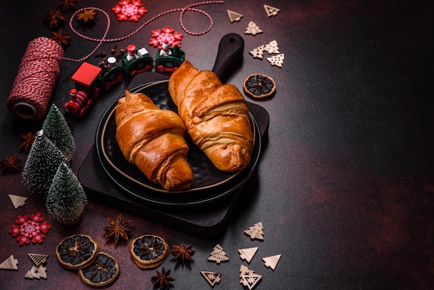 Belle diverse decorazioni natalizie e croissant su un tavolo di cemento marrone